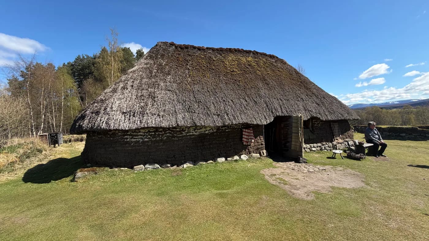 A thatched Highland cottage beneath a blue sky