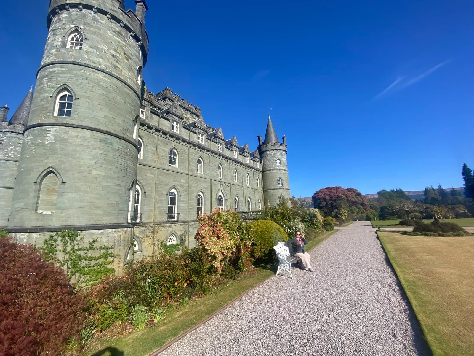 Inveraray Castle and its gardens beneath a blue sky