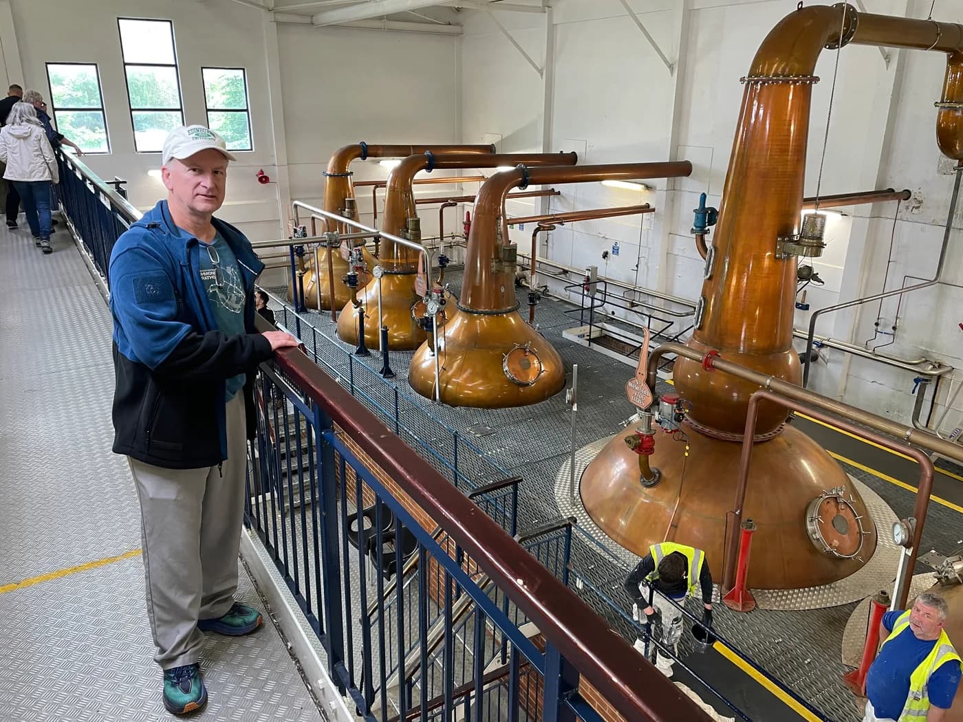 Ed beside copper whisky stills inside a distillery