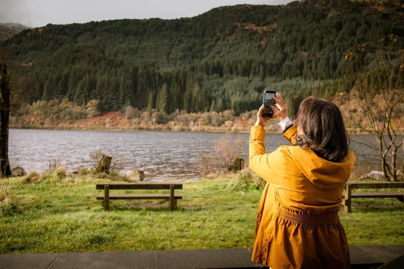 Allyson photographing a loch framed by autumn hills
