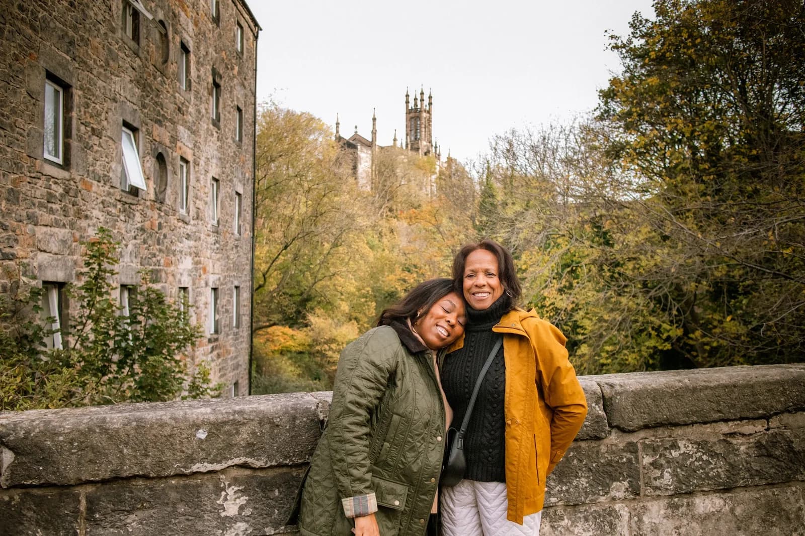 Allyson and her mother together on a stone bridge in autumn