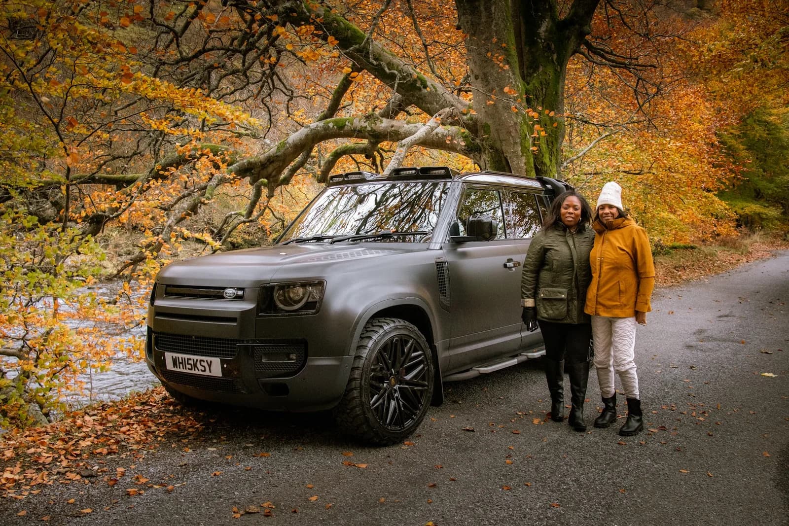 Allyson and her mother beside their vehicle in autumn woodland