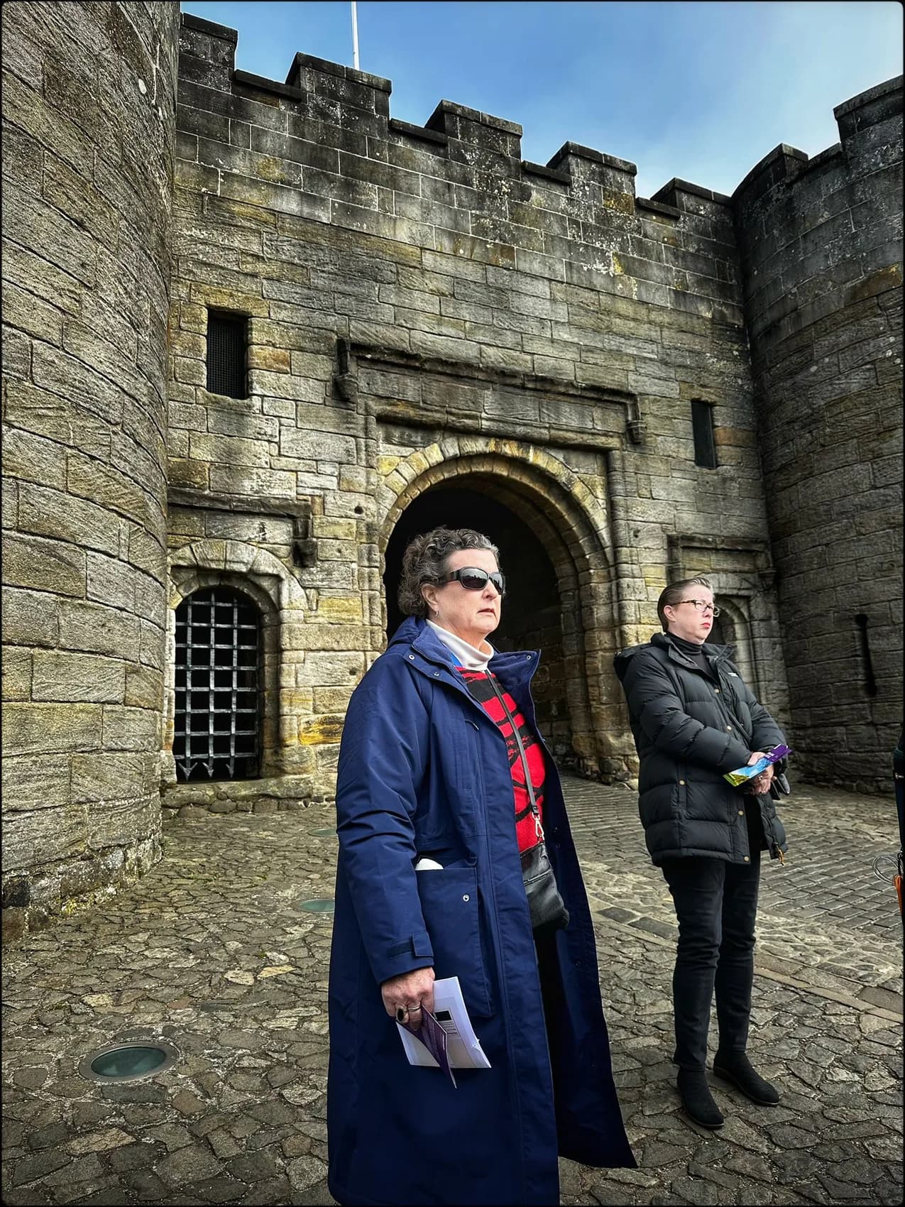 Rebecca and her sister beside a stone castle entrance