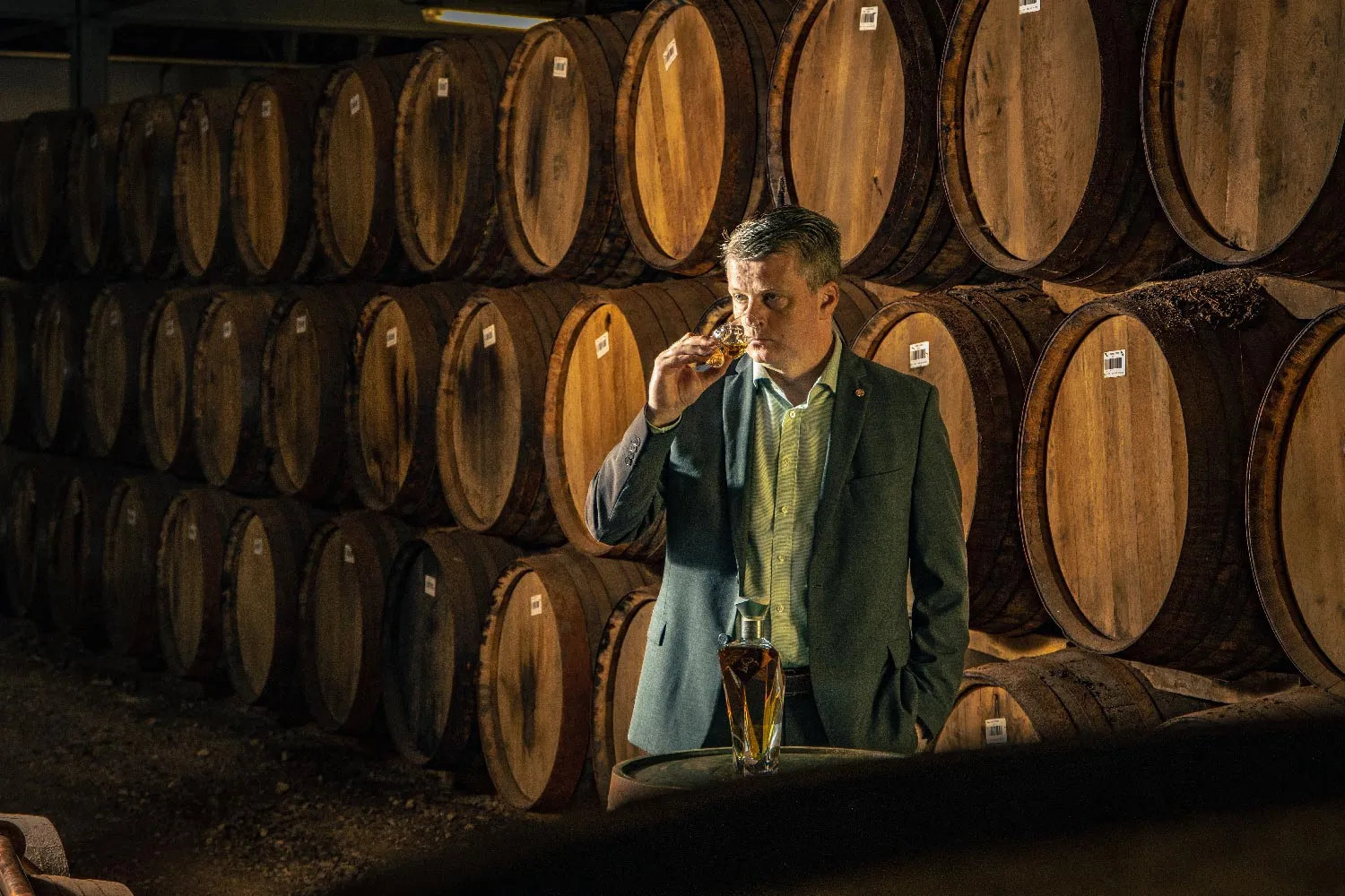 A whisky tasting among the casks in a Scottish distillery warehouse