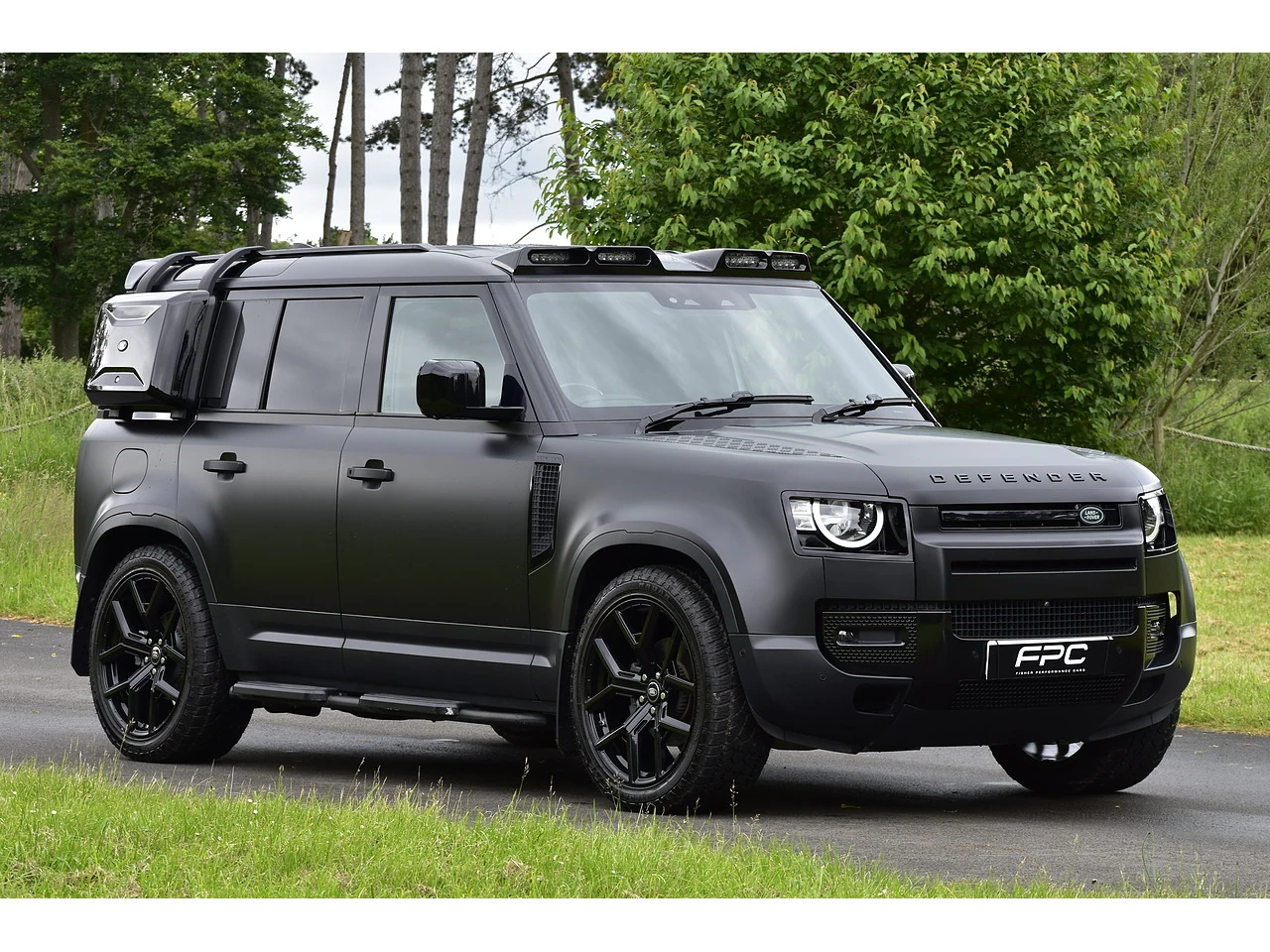 Grey Land Rover Defender 110, viewed from the front and side